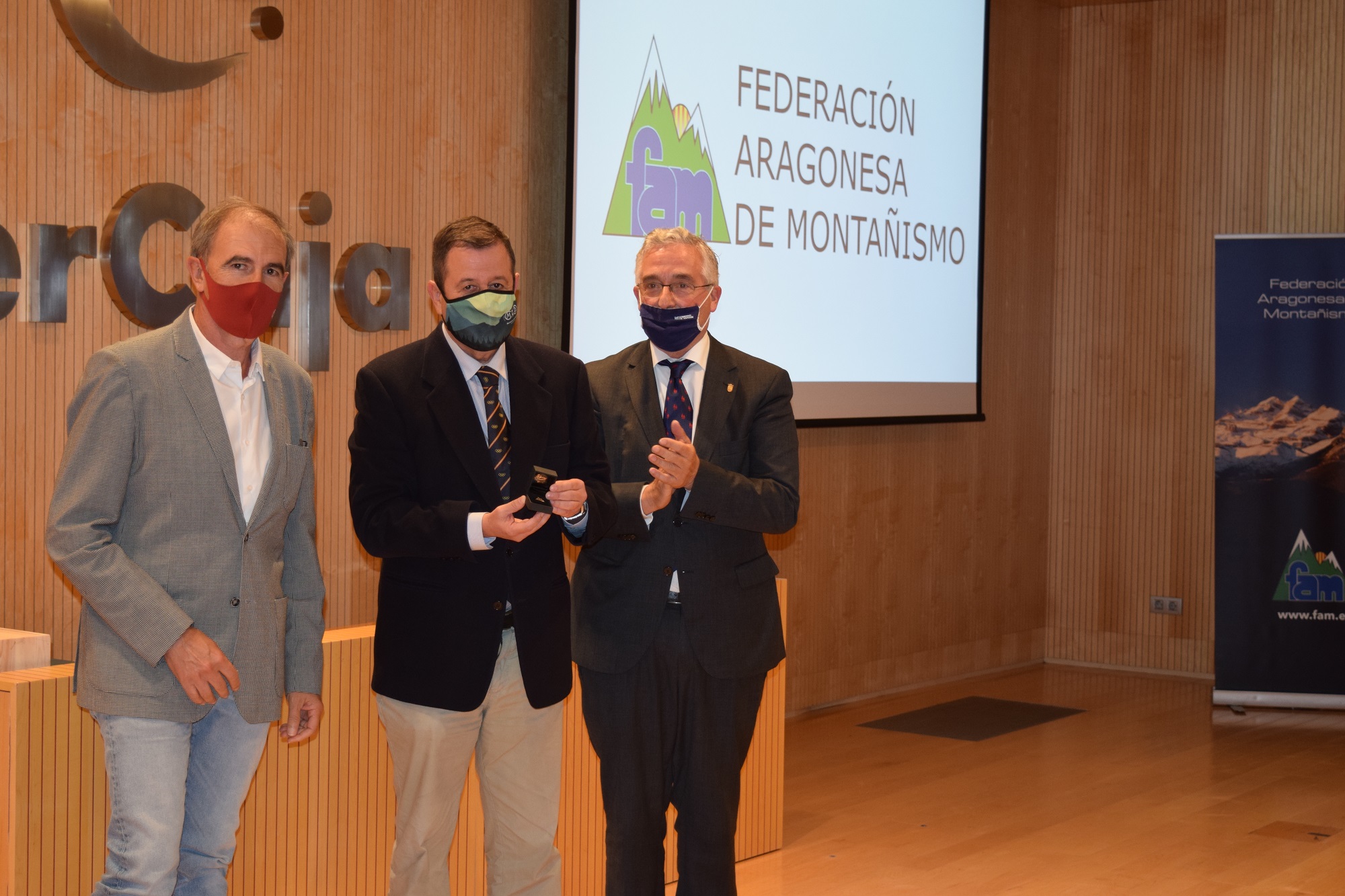 El consejero Joaquín Olona y el presidente de la FAM Javier Franco entregan la insignia de la Federación a Luis Masgrau